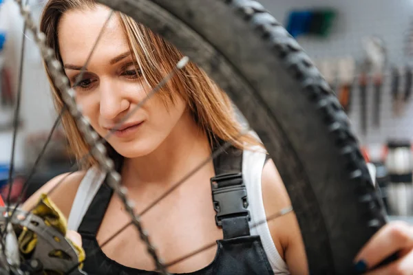 Charmante jonge craftswoman afvegen stookolie in de werkplaats — Stockfoto