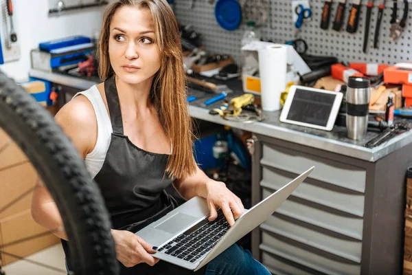 Atölyede dizüstü bilgisayar kullanarak çekici kadın makinist — Stok fotoğraf