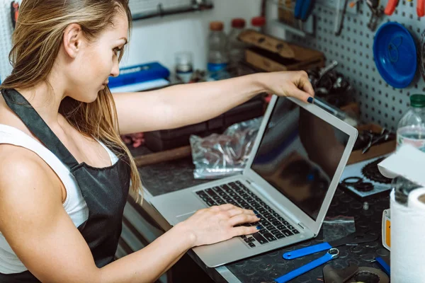 Jonge craftswoman met behulp van een laptop in de garage — Stockfoto