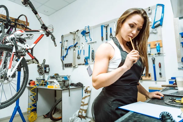 Tankeväckande kvinnlig mekaniker att skapa en skiss i verkstaden — Stockfoto