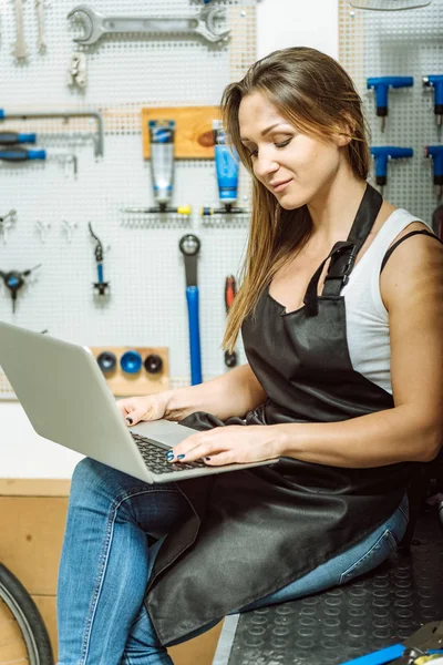 Inblandade kvinnlig mekaniker surfa på Internet i verkstaden — Stockfoto