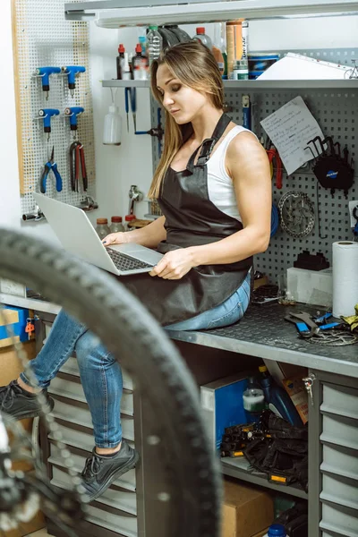 Charmiga kvinnliga tekniker använder den bärbara datorn i verkstaden — Stockfoto