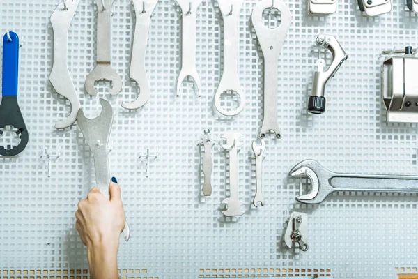 Vrouwelijke monteur het kiezen van de moer moersleutel in de werkplaats — Stockfoto