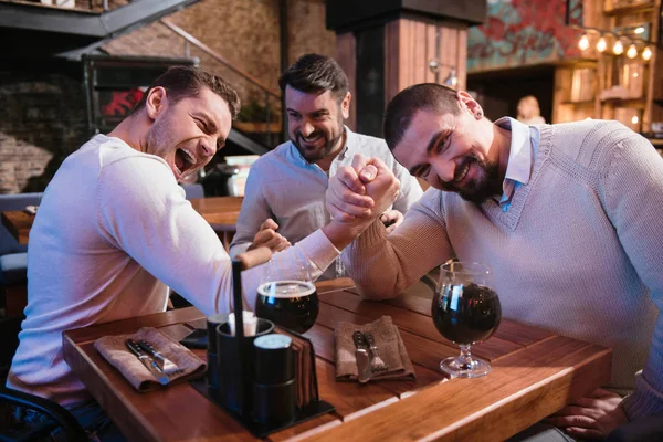 Homens simpáticos positivos decidindo quem é mais forte — Fotografia de Stock