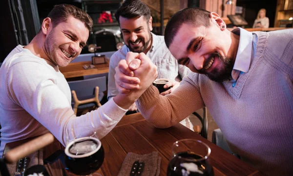 Alegre agradável homens armwrestling no bar — Fotografia de Stock