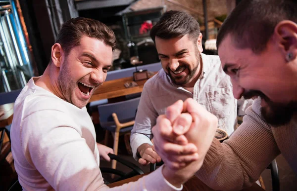 Nice handsome man trying to win the armwrestling match — Stock Photo, Image
