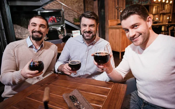 Красивые мужчины поднимают бокалы с пивом — стоковое фото