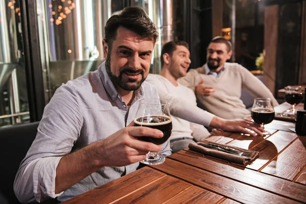 Bonito barbudo segurando um copo com cerveja — Fotografia de Stock