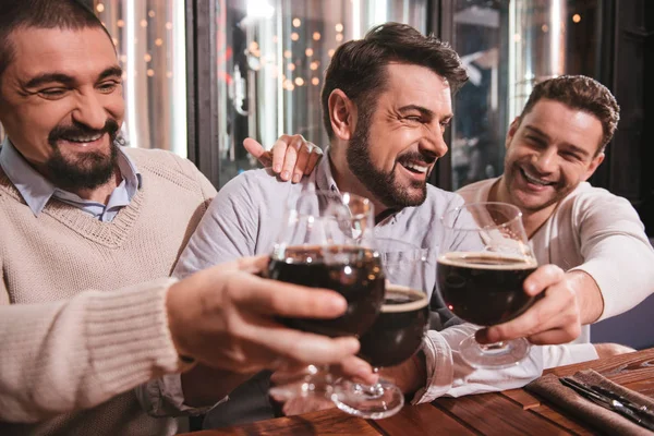 Счастливые друзья мужчины поднимают бокалы — стоковое фото
