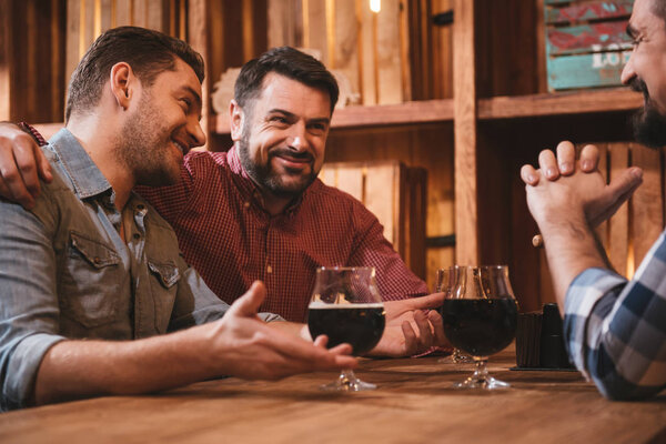 Positive bearded man hugging his friend