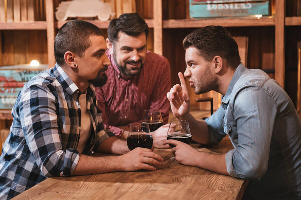 Pleasant nice man telling his friends a secret