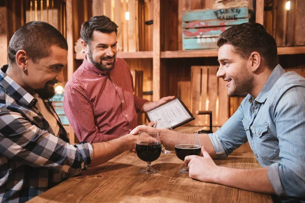 Guapos amigos encantados sentados uno enfrente del otro — Foto de Stock