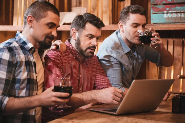 Neşeli mutlu arkadaşlar laptop ekrana bakarak