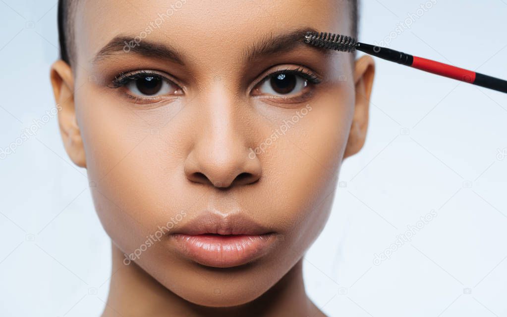 Beautiful nice woman using brush for eyebrows