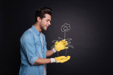 Holding bir bitki pot çekici genç adam.