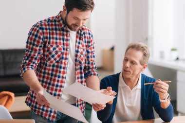 İki sayfa kağıt tutan güzel genç adam