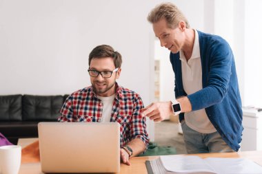 Yakışıklı gri saçlı adam dizüstü işaret