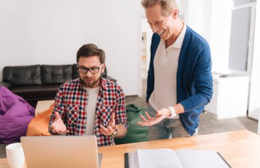 Dizüstü bilgisayarda çalışan genç esmer adam