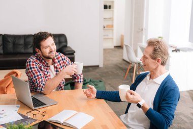 Bardak çay ile tutarak yakışıklı neşeli erkekler