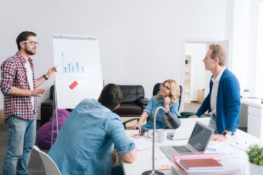 Bir diyagramı sunan ciddi genç adam