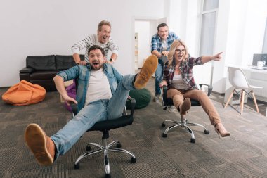 Ofis koltukları iterek olumlu neşeli erkekler
