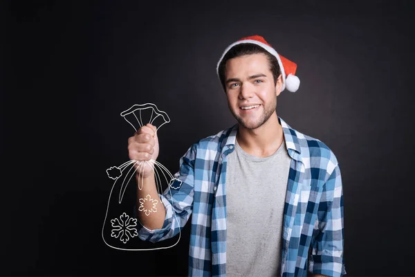 Atraente homem alegre segurando presentes de Natal . — Fotografia de Stock