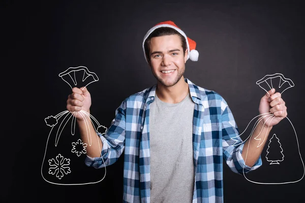 Bonito jovem segurando sacos de presentes de Natal . — Fotografia de Stock