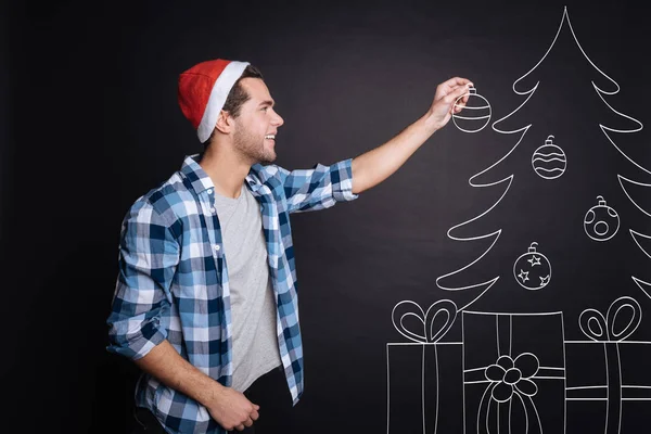 Jovem positivo decorando uma árvore de Natal . — Fotografia de Stock