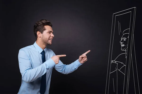 Joven guapo mirándose en un espejo . — Foto de Stock