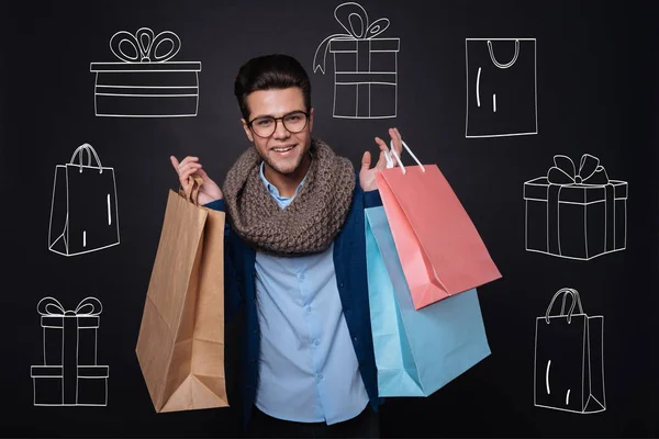 Przystojny młody mężczyzna trzyma torby na zakupy i prezenty. — Zdjęcie stockowe