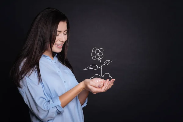 Joven alegre sosteniendo la flor — Foto de Stock