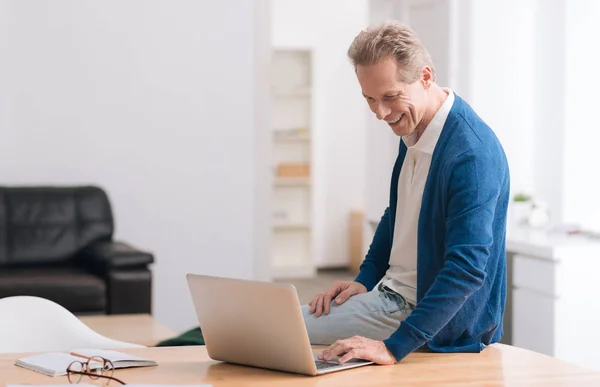 Glad positiv man sitter på bord — Stockfoto