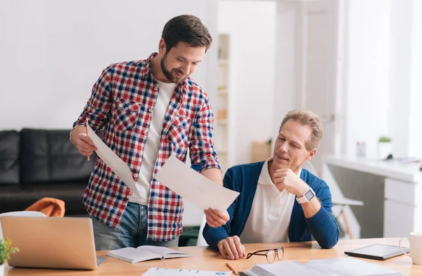 Hombre barbudo guapo mostrando sus bocetos al colega — Foto de Stock