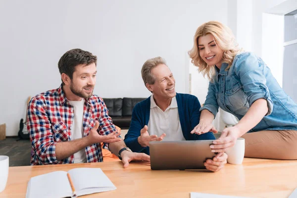 Schöne, fröhliche Frau sitzt auf dem Tisch — Stockfoto