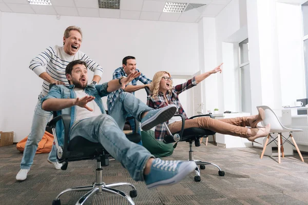 Gente alegre y feliz sentada en las sillas de la oficina — Foto de Stock