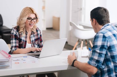 Onun meslektaşım oturan mutlu sarışın kadın