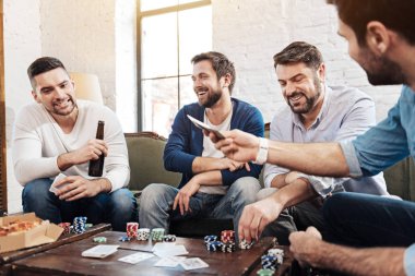 Neşeli keyifli erkekler poker oyunu oynarken