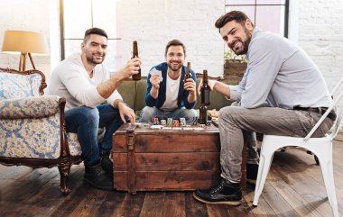 Cheerful positive men playing card games clipart
