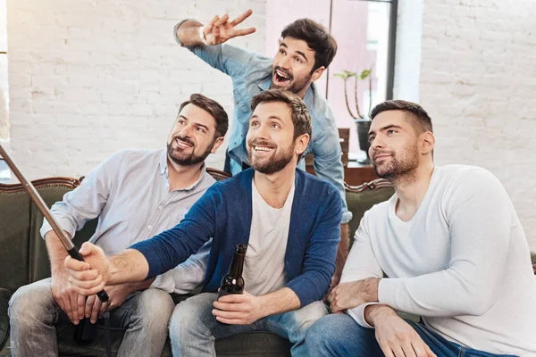 Alegre barbudo sosteniendo un palo selfie — Foto de Stock