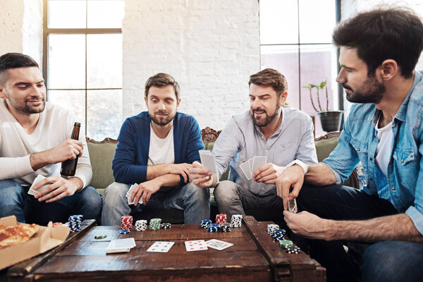 Good looking male friends playing poker