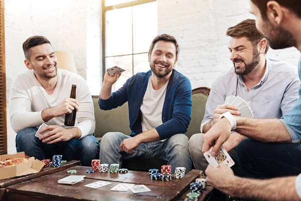 Vrolijke blij man zijn kaarten op tafel zetten — Stockfoto
