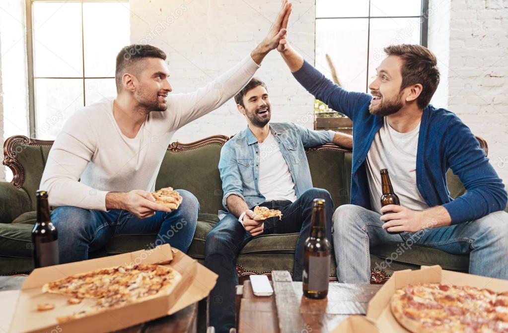 Handsome delighted men giving high five