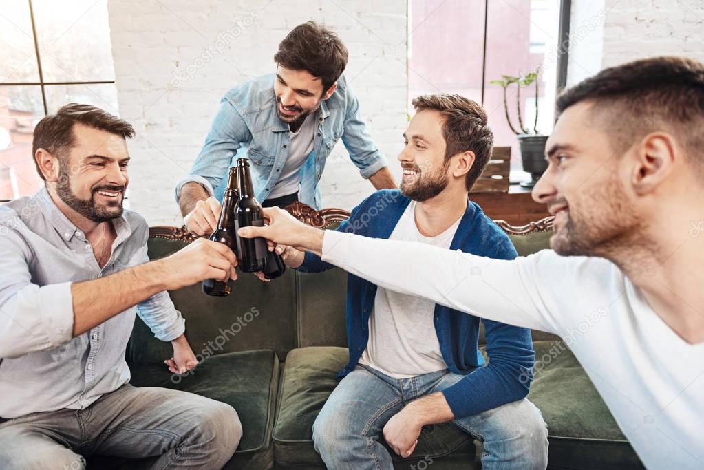 Delighted positive men enjoying beer