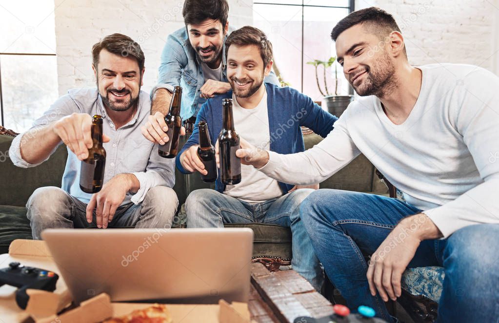 Happy cheerful men drinking beer with their online friends