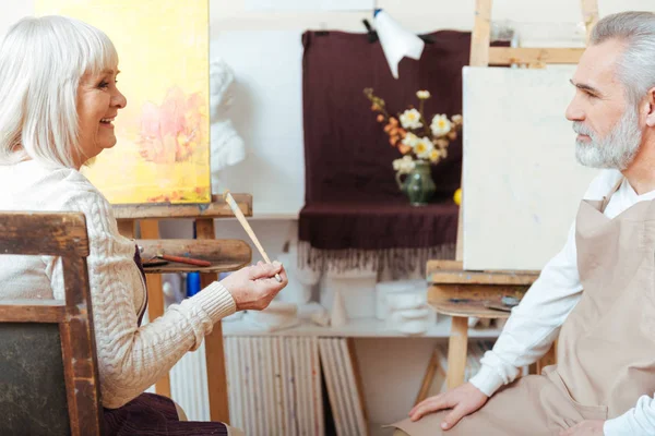 Мужчины и женщины-художницы сидят вместе в классе живописи — стоковое фото