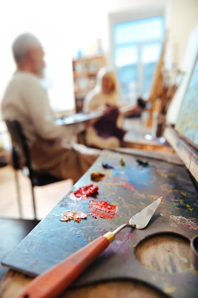 El primer plano de las pinturas y el pincel acostado sobre la mesa — Foto de Stock
