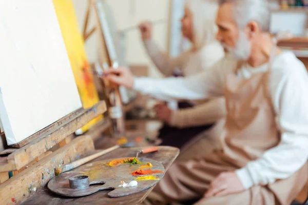 Artista masculino pintando um quadro em classe — Fotografia de Stock