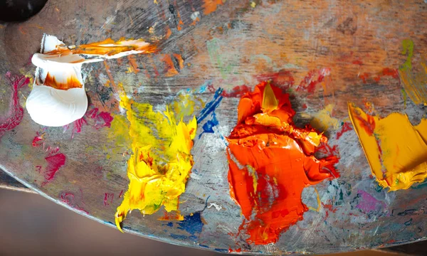 White yellow and orange paints on a palette