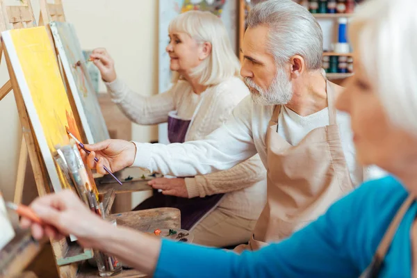 Three professional artists spending time in painting studio — Stock Photo, Image