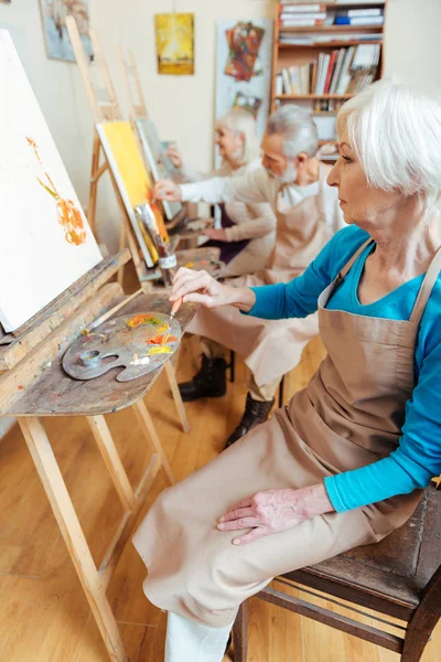 Tres artistas profesionales pasan tiempo en el estudio de pintura —  Fotos de Stock